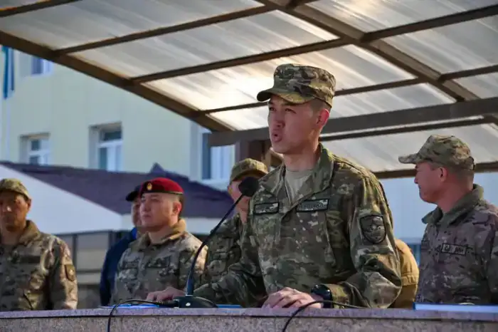 В Астане солдаты, призванные весной, прощаются с боевым знаменем на фоне международной службы