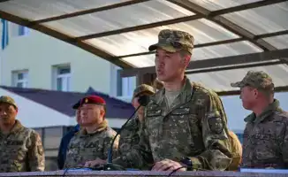 В Астане солдаты, призванные весной, прощаются с боевым знаменем на фоне международной службы
